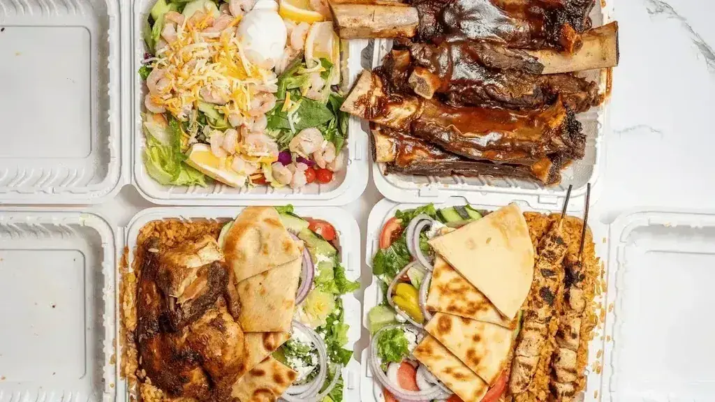 A takeout spread of shrimp salad, BBQ ribs, a chicken gyro plate, and a kebob plate at Harry's Cafe, Katella Ave, Stanton, CA