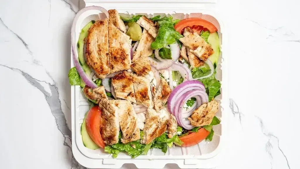 A grilled chicken salad in a to-go container at Harry's Cafe, Katella Ave, Stanton, CA
