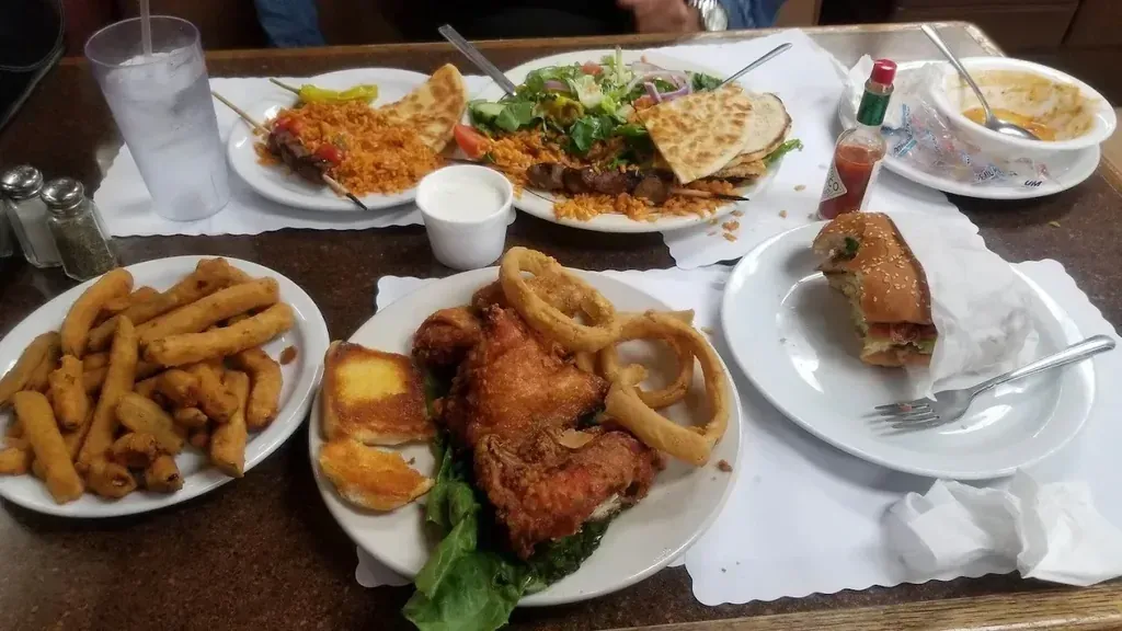 Kebob plates and fried chicken with a gyro and fried sides on one table at Harry's Cafe, Katella Ave, Stanton, CA