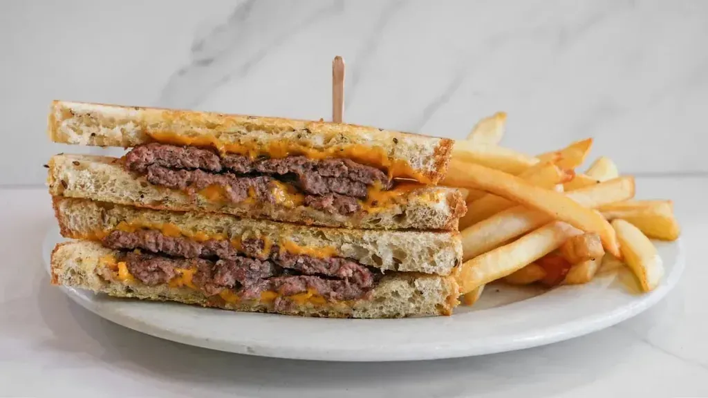 A patty melt cut in half with french fries at Harry's Cafe, Katella Ave, Stanton, CA