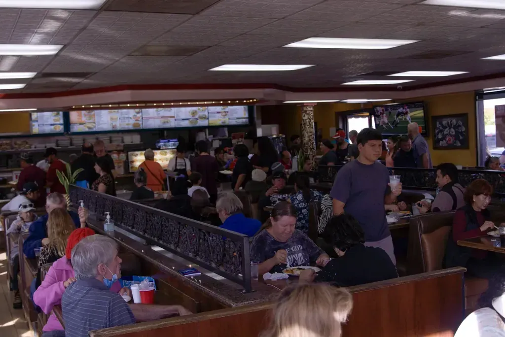 A full dining room at the Harry's Cafe restaurant on Katella Avenue, Stanton, CA, with the overhead menu boards behind the counter