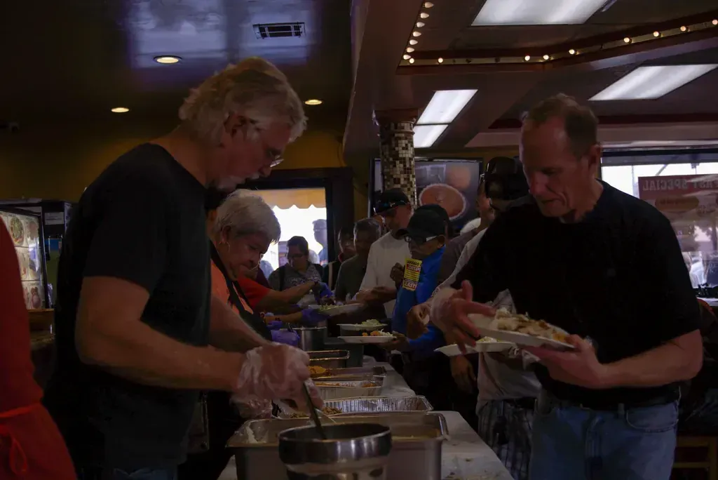 Volunteers serving plates at the free Thanksgiving dinner at Harry's Cafe, Katella Ave, Stanton, CA
