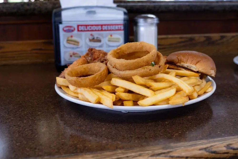 A plate of french fries and onion rings with a bun at Harry's Cafe, Katella Ave, Stanton, CA