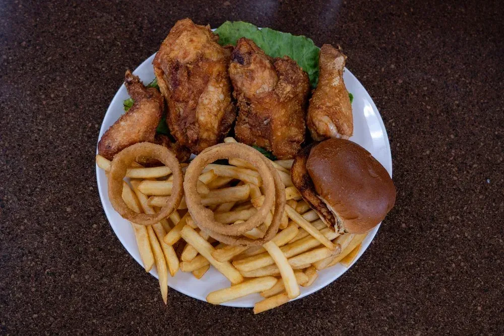 A broasted chicken plate with onion rings, a bun and french fries, from above at Harry's Cafe, Katella Ave, Stanton, CA