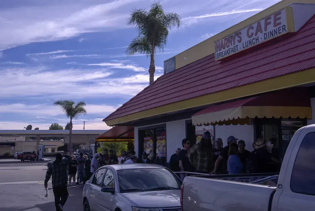 The storefront and the line at the door seen from the parking lot at Harry's Cafe, Katella Ave, Stanton, CA