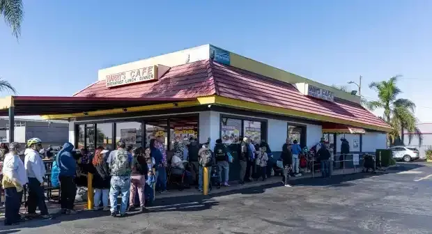A crowd waiting outside the storefront on Thanksgiving at Harry's Cafe, Katella Ave, Stanton, CA